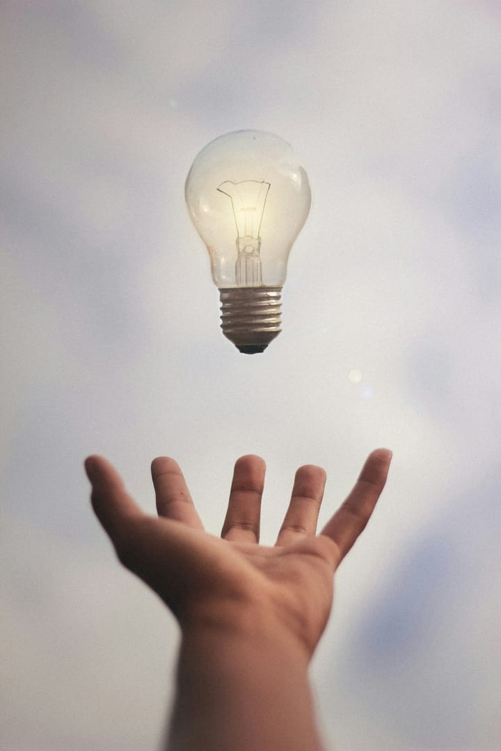 main ouverte avec ampoule électrique flottant au dessus pour symboliser l'énergie émise par la paume de la main. 